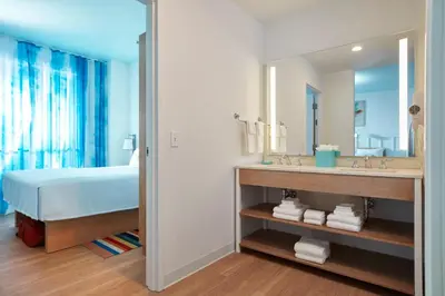 a bathroom with a bed and a sink and a mirror at Universal's Endless Summer Resort - Surfside Inn and Suites in Orlando