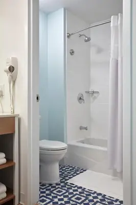 a bathroom with a toilet and a tub and a sink at Universal's Endless Summer Resort - Surfside Inn and Suites in Orlando