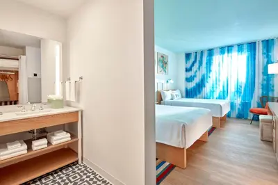 a hotel room with a bed and a bathroom at Universal's Endless Summer Resort - Surfside Inn and Suites in Orlando