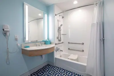 a bathroom with a sink and a tub and a shower at Universal's Endless Summer Resort - Surfside Inn and Suites in Orlando