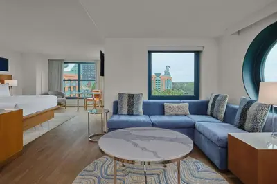 a living room with a blue couch and a bed at Walt Disney World Swan in Orlando
