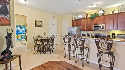 a kitchen with a bar with chairs and a table at Executive 3 Bedroom Villa at Universal,Convention Center, Vista Cay in Orlando