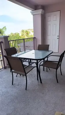 a glass table and two chairs on a balcony at Executive 3 Bedroom Villa at Universal,Convention Center, Vista Cay in Orlando
