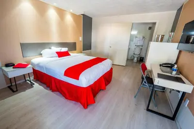 a hotel room with a large bed and a desk at Travelodge by Wyndham Orlando at Heart of International Drive in Orlando