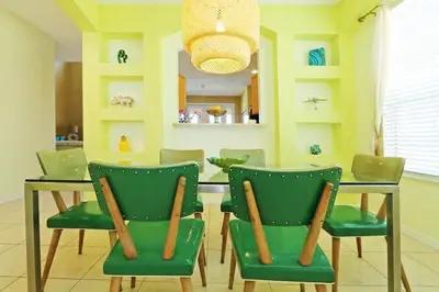 a dining room with a table and green chairs at Aquamarine Hideaway in Kissimmee
