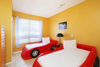 a bedroom with two beds and a red car bed at Aquamarine Hideaway in Kissimmee