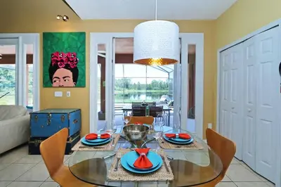 a dining room with a glass table and chairs at Aquamarine Hideaway in Kissimmee