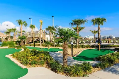 a golf course with palm trees and a putting green at Modern Luxury Villa with Everything in Kissimmee