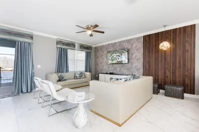 a living room with a white couch and a ceiling fan at Modern Luxury Villa with Everything in Kissimmee