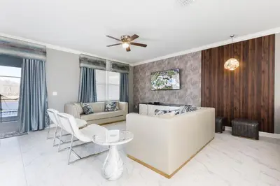 a living room with a white couch and a ceiling fan at Modern Luxury Villa with Everything in Kissimmee