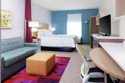 a hotel room with a bed and a couch at Home2 Suites By Hilton Orlando South Park - Near Epic Universe in Orlando