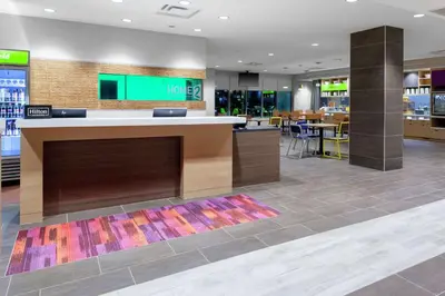 a lobby of a store with a counter and a restaurant at Home2 Suites By Hilton Orlando South Park - Near Epic Universe in Orlando