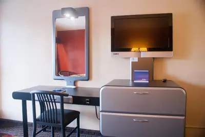 a room with a desk with a tv and a chair at Super 8 by Wyndham Kissimmee/Maingate/Orlando Area in Orlando