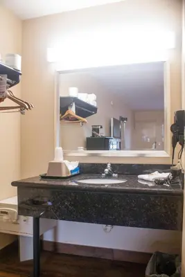 a bathroom with a sink and a large mirror at Super 8 by Wyndham Kissimmee/Maingate/Orlando Area in Orlando