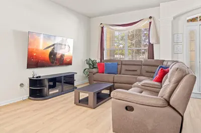a living room with a couch and a tv at Flagstone Villa in Orlando