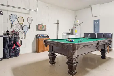 a room with a pool table and rackets at Flagstone Villa in Orlando