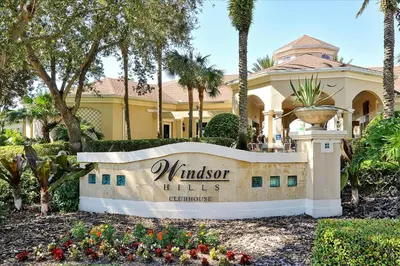 a sign in front of a building with palm trees at Flagstone Villa in Orlando