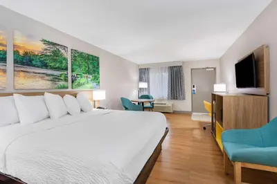 a hotel room with a bed and a flat screen tv at Days Inn by Wyndham N Orlando/Casselberry in Orlando