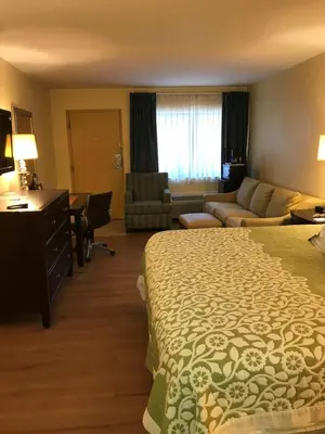 a hotel room with a bed and a desk at Days Inn by Wyndham N Orlando/Casselberry in Orlando