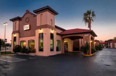 a building with a sign that reads motel at Red Roof Inn Orlando South - Florida Mall in Orlando