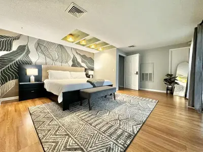 a bedroom with a large bed and a rug at Spacious Lakefront House with Pool, Hottub, & Boating in Orlando