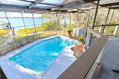 a swimming pool with a view of the water at Spacious Lakefront House with Pool, Hottub, & Boating in Orlando
