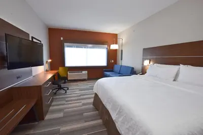a hotel room with a bed and a flat screen tv at Holiday Inn Express & Suites - Orlando - Southeast by IHG in Orlando