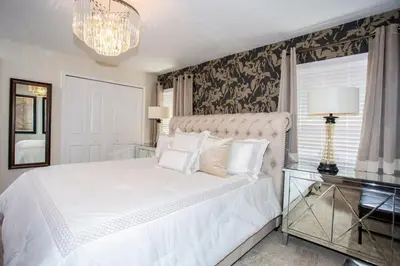 a bedroom with a large white bed and a chandelier at Four Bedrooms at StoreyLakeResort 3063 in Kissimmee