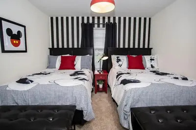 two beds in a bedroom with red and black stripes at Four Bedrooms at StoreyLakeResort 3063 in Kissimmee