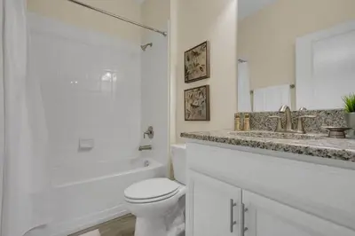 a white bathroom with a toilet and a sink at Five Bedrooms Single Family 4759 in Kissimmee