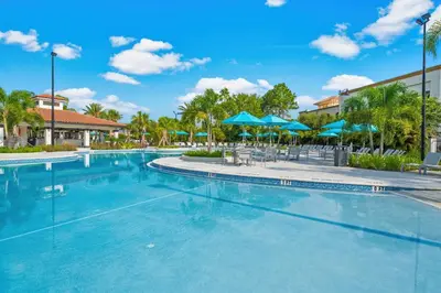a swimming pool at a resort with blue umbrellas at Cayview Avenue Unit 103 Condo in Orlando