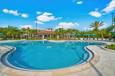 a large swimming pool at a resort with umbrellas at Shoreway Loop Unit 108 Condo in Orlando