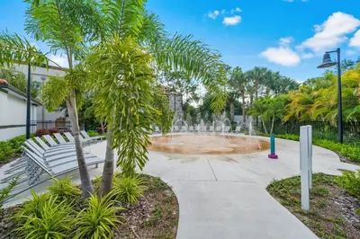 a fountain in a park with a bench and palm trees at Tideview Circle Unit 38 Condo in Orlando
