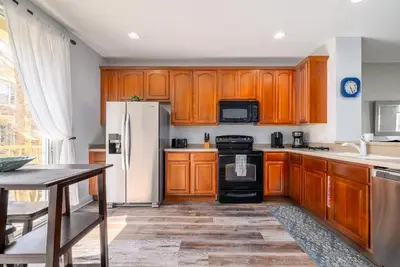 a kitchen with wooden cabinets and a white refrigerator at Tideview Circle Unit 38 Condo in Orlando