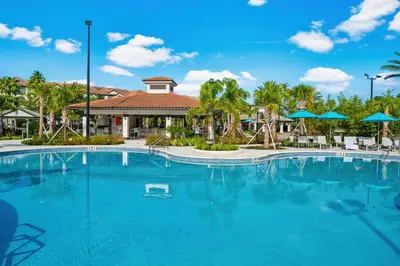 a large pool at a resort with chairs and umbrellas at Cayview Avenue Unit 404 Condo in Orlando