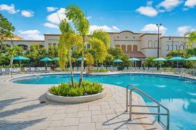 a pool at a resort with chairs and umbrellas at Shoreway Loop Unit 407 Condo in Orlando