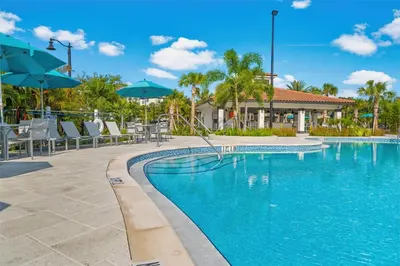 a swimming pool with chairs and umbrellas at a resort at Tideview Circle Avenue Unit 59 Condo in Orlando