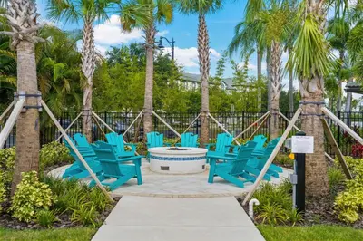 a group of blue chairs on a patio with palm trees at Tideview Circle Avenue Unit 59 Condo in Orlando