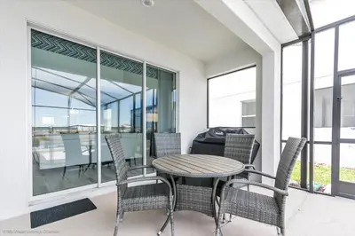 a patio with a table and chairs on a balcony at Beautiful Home wPrivate Pool & Spa, near WDW in Kissimmee