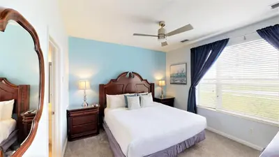 a bedroom with a large bed and a mirror at Lovely Townhome at Vista Cay Resort near WDW in Orlando