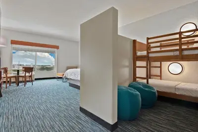 a hotel room with two bunk beds and a table at Holiday Inn Express & Suites Orlando- Lake Buena Vista by IHG in Orlando