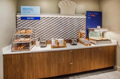 a bakery with a counter with donuts on it at Holiday Inn Express & Suites Orlando- Lake Buena Vista by IHG in Orlando