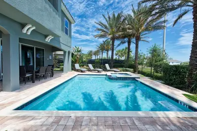 a swimming pool in the backyard of a house with palm trees at Private Pool And Game Room With Waterpark & Resort Access At Encore Resorts Reunion - 141La in Kissimmee