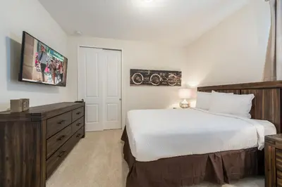 a bedroom with a large bed and a dresser at Elegant Home Near Disney With Private Pool And Waterpark & Resort Access At Encore Resorts Reunion - 7393Mr in Kissimmee