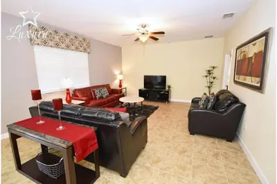 a living room with leather furniture and a ceiling fan at Holiday Villas of Kissimmee in Kissimmee
