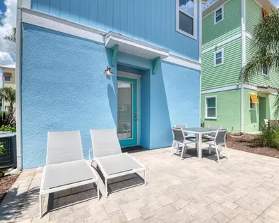 a patio with chairs and a table next to a building at Margaritaville Cottages Orlando by Rentyl with H2O Waterpark in Kissimmee