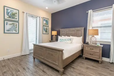 a bedroom with a large bed and two windows at Margaritaville Cottages Orlando by Rentyl with H2O Waterpark in Kissimmee