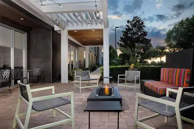 a patio with chairs and a couch and a fire pit at Home2 Suites By Hilton Clermont in Clermont
