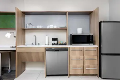 a kitchen with a refrigerator and a microwave at Home2 Suites By Hilton Clermont in Clermont