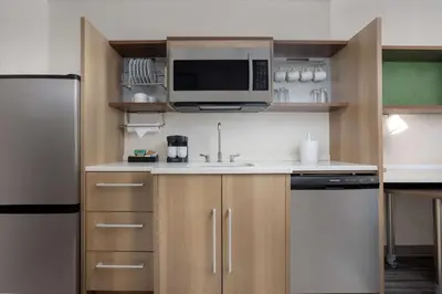 a small kitchen with a sink and a microwave at Home2 Suites By Hilton Clermont in Clermont